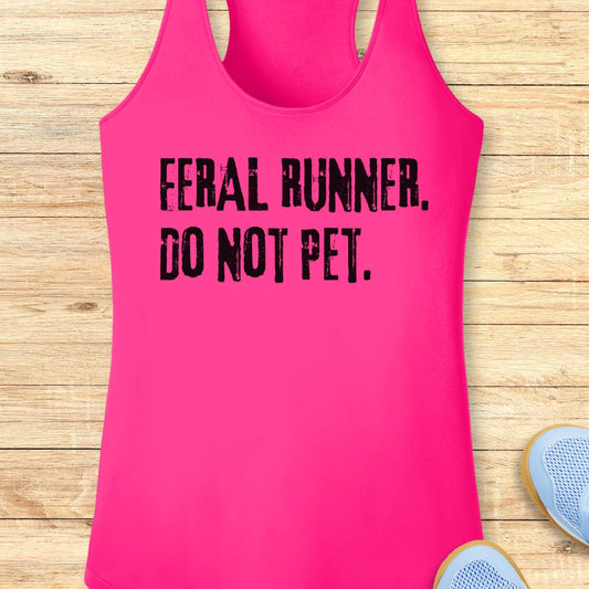 A bright pink racerback performance tank top with the text 'FERAL RUNNER. DO NOT PET.