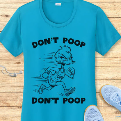Graphic print t-shirt featuring a vibrant teal blue shirt with an angry cartoon duck runner wearing a 'CRAP' tank top and 'DON'T POOP' text, laid out on a wooden surface alongside white earbuds and light blue running shoes