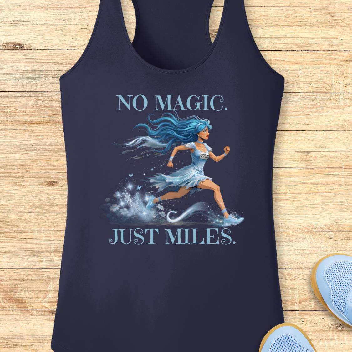 A navy blue racerback tank top laid flat on a light wood background, featuring a graphic of a running woman with blue hair and the text 'NO MAGIC. JUST MILES.