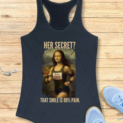 Flat lay graphic print of Leonardo da Vinci's Mona Lisa on a dark blue tank top showing Mona Lisa as a runner in a green singlet with a Mona 260 bib against her painting's iconic hazy landscape, featuring the humorous phrases HER SECRET and THAT SMILE IS 90% PAIN, all resting on a wooden plank background with light blue running shoes and white earbuds