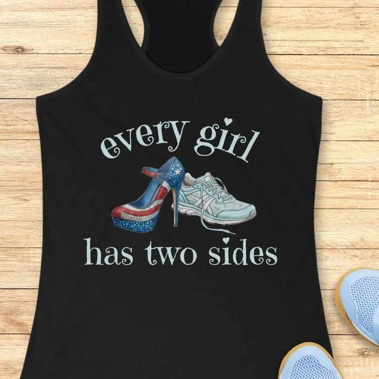 Black tank top with graphic of high heels and sneakers with text 'Every girl has two sides' on a wooden surface.