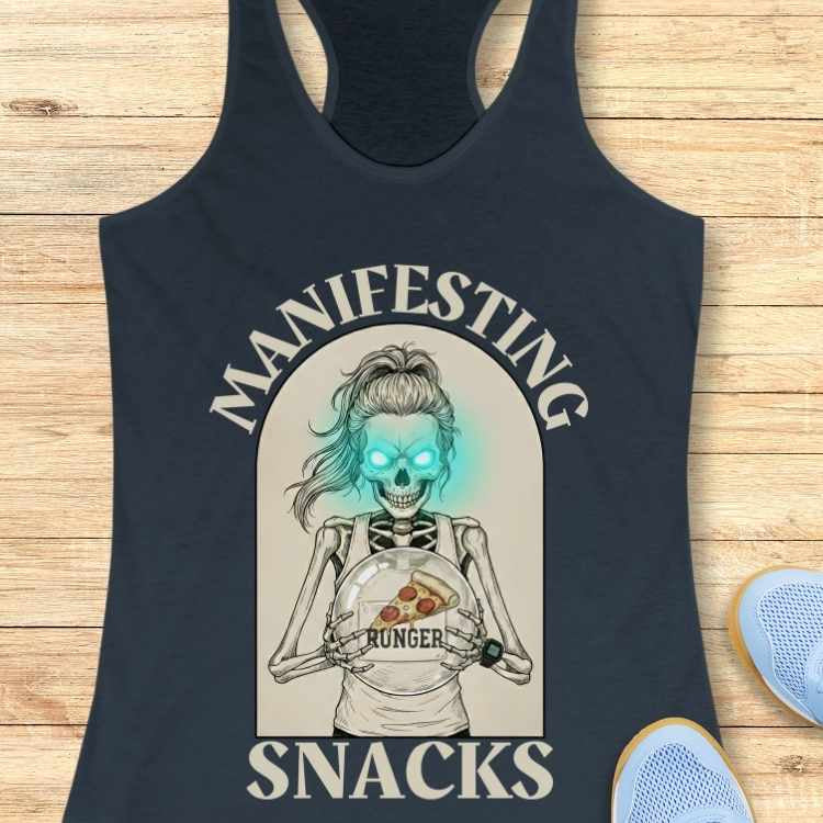 Black tank top with a graphic design of a skeleton holding a pizza, text 'Manifesting Snacks', on a wooden surface.