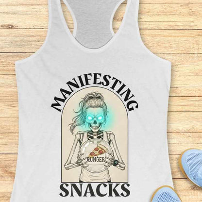 white tank top with skeleton design and text 'Manifesting Hunger Snacks' on a wooden surface.