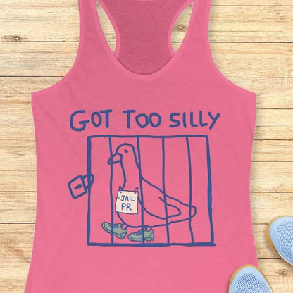 Pink racerback tank top depicting a blue line art drawing of a pigeon in a cage wearing green sneakers and holding a JAIL PR sign, with the phrase GOT TOO SILLY printed above, all against a light wooden plank background