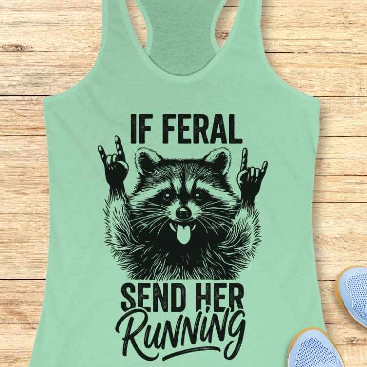 Mint green tank top with raccoon graphic and text on a wooden surface