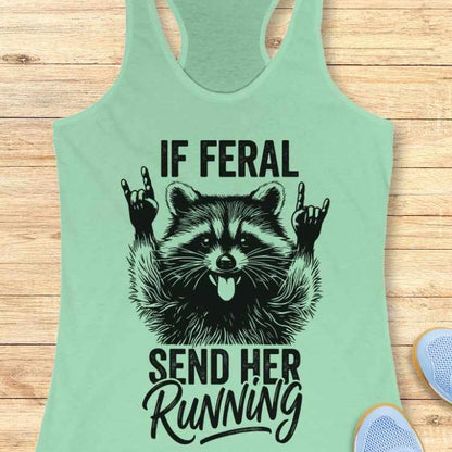 Mint green tank top with raccoon graphic and text on a wooden surface