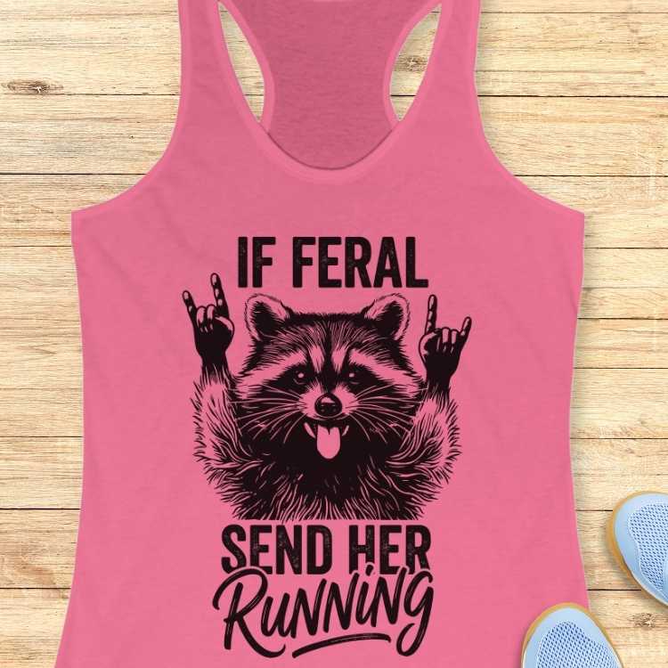 Pink tank top with a raccoon graphic and text on a wooden surface