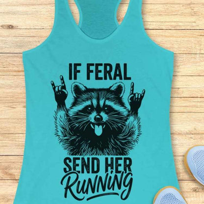 Turquoise tank top with a raccoon graphic and text on a wooden surface