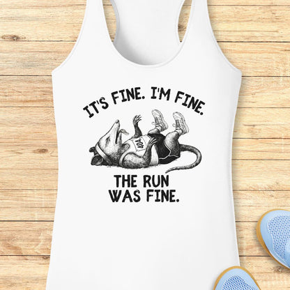 White performance racerback tank top with a black graphic of a running person and the text 'IT'S FINE. I'M FINE.