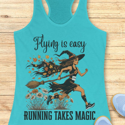 Turquoise tank top with a witch graphic and text 'Flying is easy, running takes magic' on a wooden surface