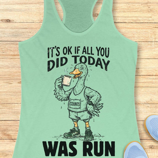 Mint green tank top with a graphic of a duck and text "it's ok if all you did today was run" on a wooden surface