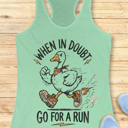 Mint green tank top with a graphic of a duck and text 'When in doubt, go for a run' on a wooden surface.