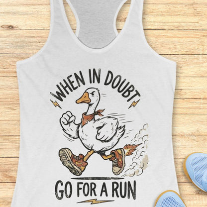 White  tank top with a graphic of a duck and text 'When in doubt, go for a run' on a wooden surface.