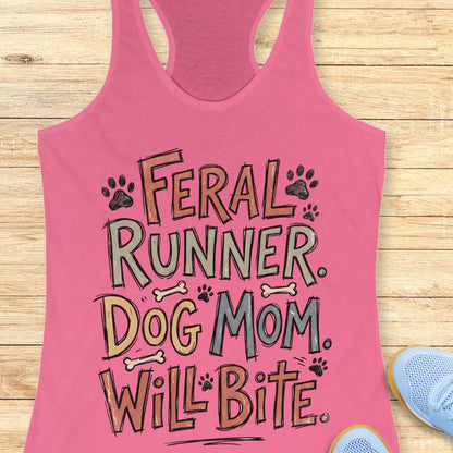 Pink tank top with text 'Feral Runner. Dog Mom. Will Bite' on a wooden surface.