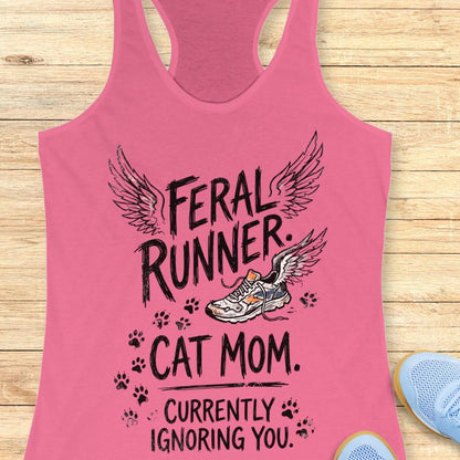 mint tank top with the text "feral runner. cat mom. currently ignoring you." on a wooden background