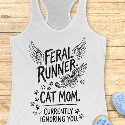 white tank top with the text "feral runner. cat mom. currently ignoring you." on a wooden background