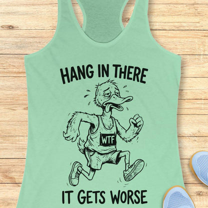 mint tank top with an image of a duck and text "hang in there it gets worse" on a wooden background