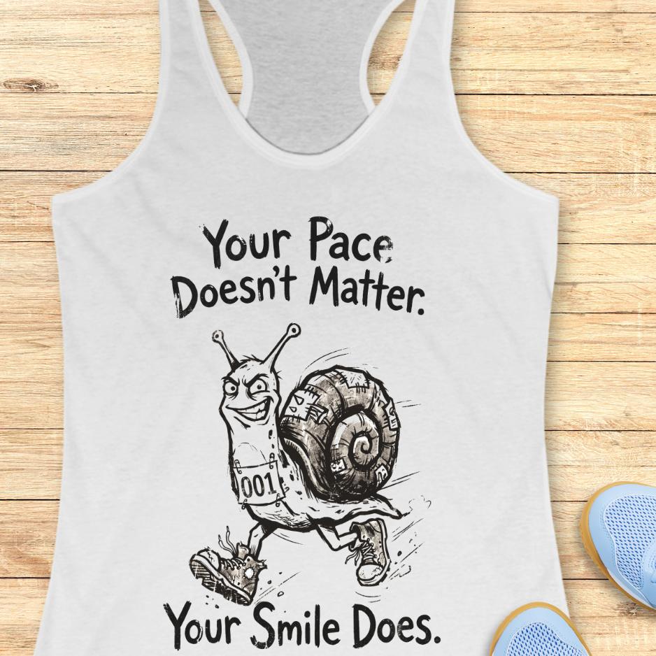 white tank top with an image of a running snail , smiling, and text - "your pace doesn't matter. Your smile does." on a wooden background