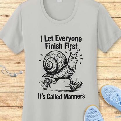 Gray t-shirt with a snail graphic and text on a wooden surface