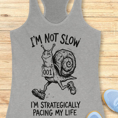 grey tank top with a running snail and text - I'm not slow I'm strategically pacing my life on a wooden background