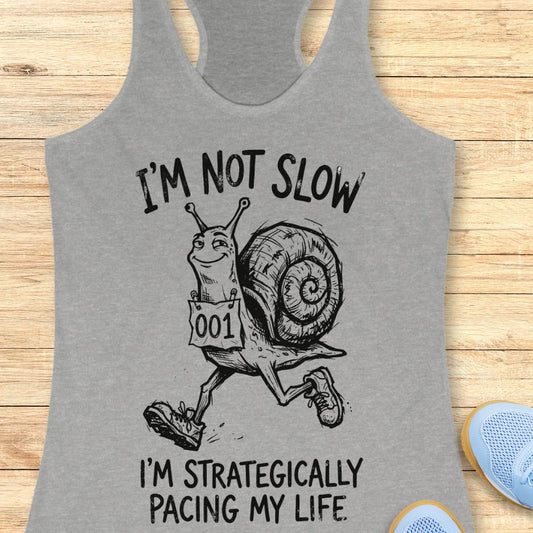 grey tank top with a running snail and text - I'm not slow I'm strategically pacing my life on a wooden background