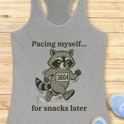 grey tank top with a running raccoon and text "pacing myself...for snacks later" on a wooden background