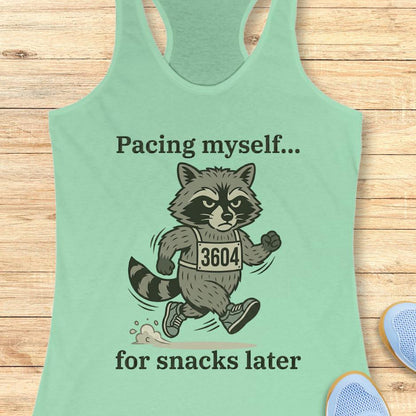 mint tank top with a running raccoon and text "pacing myself...for snacks later" on a wooden background