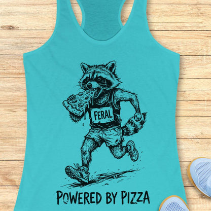 blue tank top with a raccoon runner, with a bib that says - feral, and it is eating a slice of pizza. The tank top has the text  -powered by pizza, and it's on a wooden background