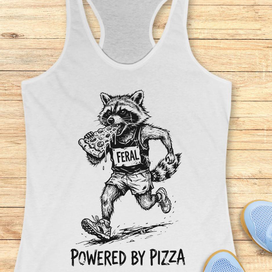 white tank top with a raccoon runner, with a bib that says - feral, and it is eating a slice of pizza. The tank top has the text  -powered by pizza, and it's on a wooden background