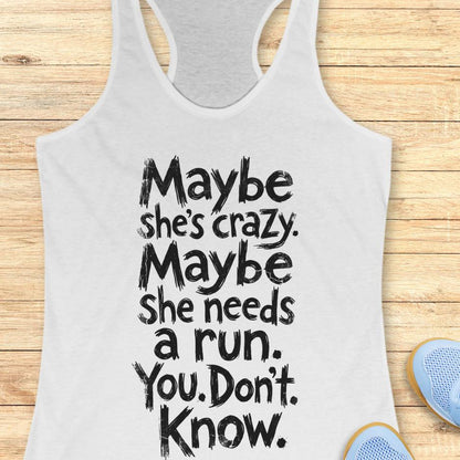 white tank top with text - maybe she's crazy. Maybe she needs a run. You. Don't. Know.  on a wooden background
