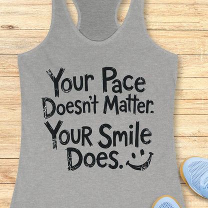 grey tank top with the text - your pace doesn't matter. your smile does. on a wooden background