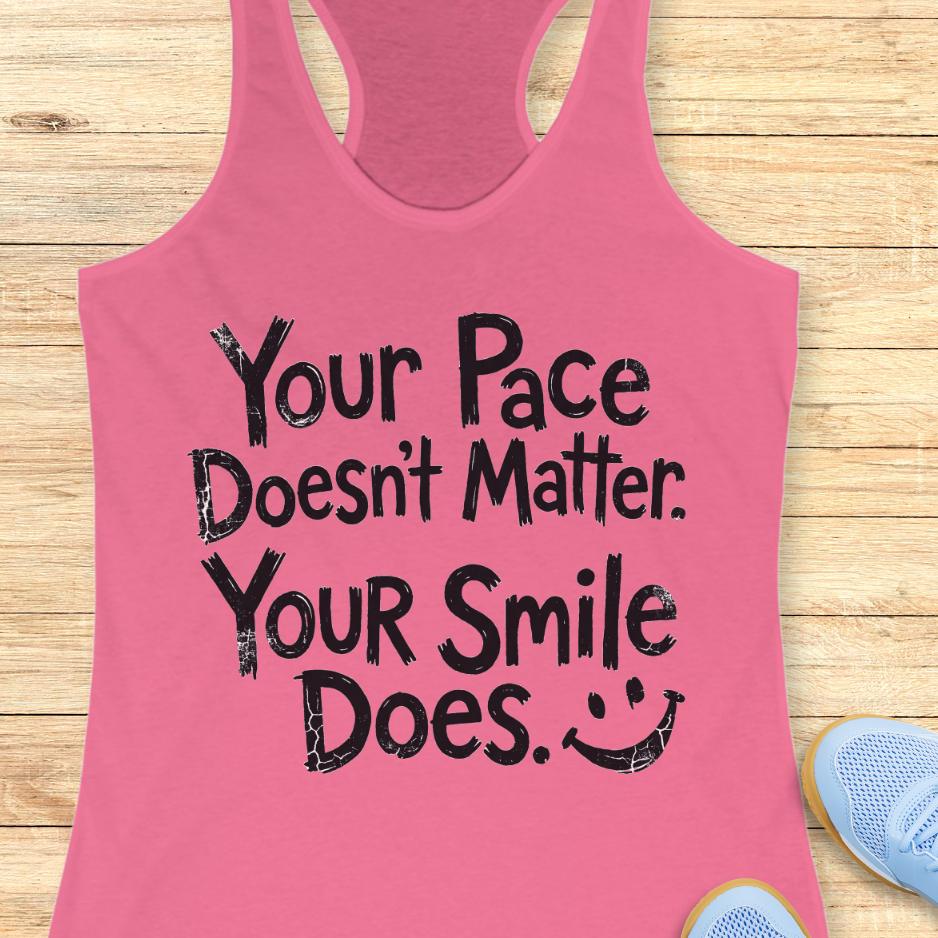 pink tank top with the text - your pace doesn't matter. your smile does. on a wooden background