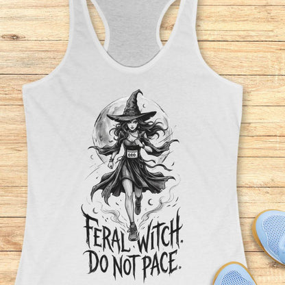 white tank top with an image of a running witch and the text - feral witch. Do not pace. on a wooden background