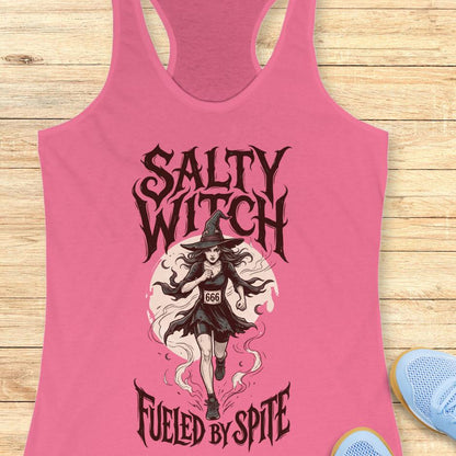 pink tank top with an image of a running witch and the text - salty witch. Fueled by spite. on a wooden background