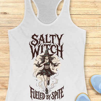 white tank top with an image of a running witch and the text - salty witch. Fueled by spite. on a wooden background
