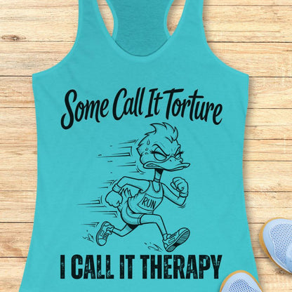 Turquoise tank top with cartoon character and text - some call it torture. I call it therapy.  on a wooden surface