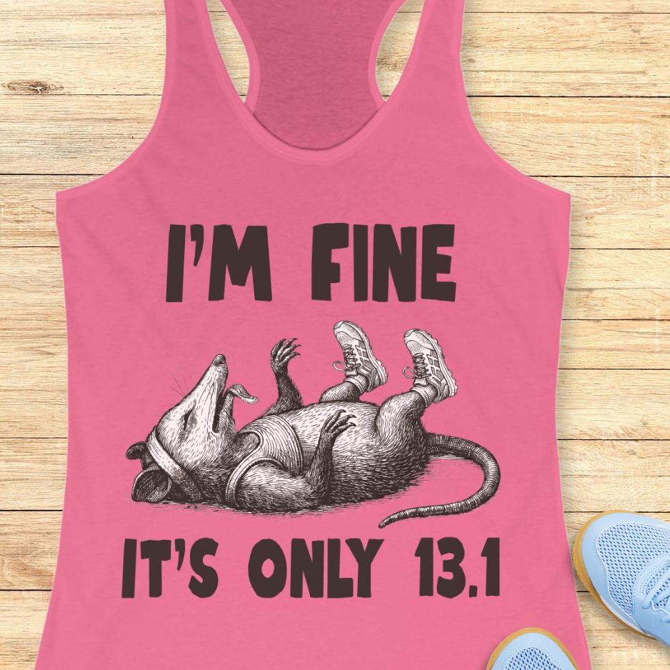 Pink tank top with a graphic of a rat and text 'I'm fine it's only 13.1' on a wooden surface.