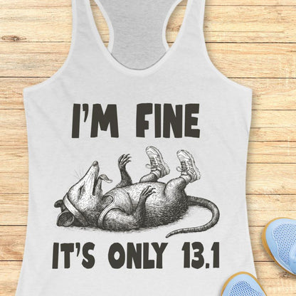 white tank top with armadillo graphic and text 'I'm fine it's only 13.1' on a wooden surface.