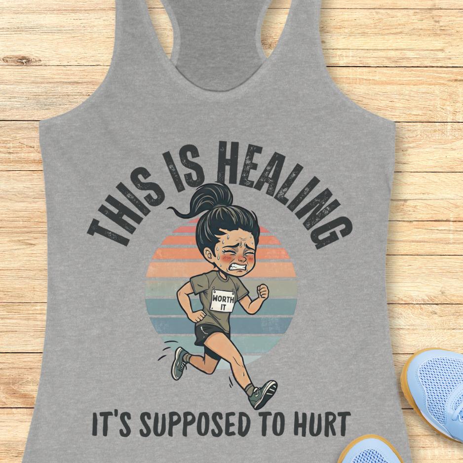 grey tank top with an image of a woman running and a text - this is healing, it's supposed to hurt, on a wooden background