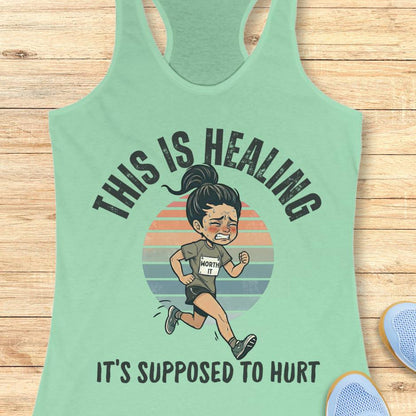 mint tank top with an image of a woman running and a text - this is healing, it's supposed to hurt, on a wooden background