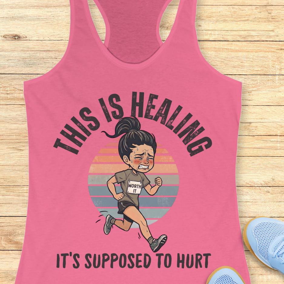 pink tank top with an image of a woman running and a text - this is healing, it's supposed to hurt, on a wooden background