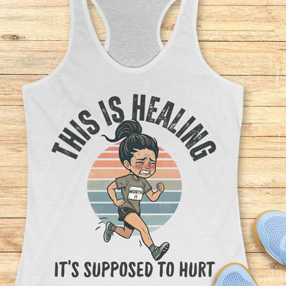 white tank top with an image of a woman running and a text - this is healing, it's supposed to hurt, on a wooden background