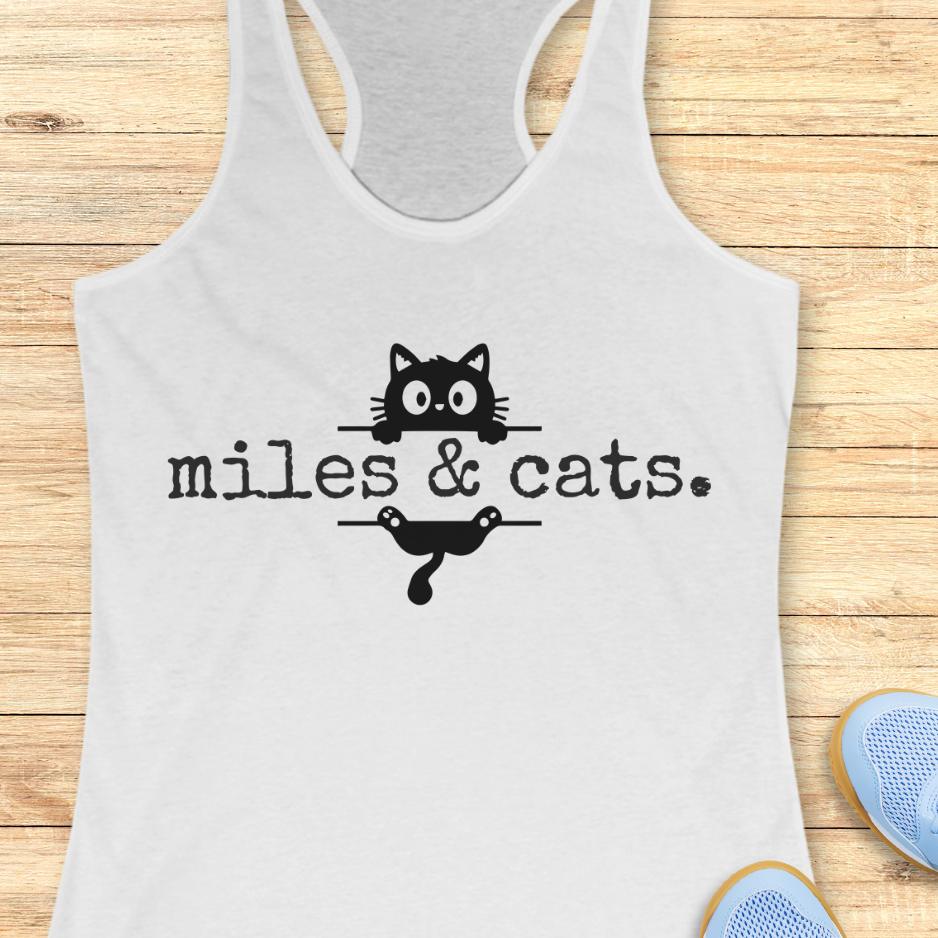 white tank top with 'miles & cats.' text and cat illustrations on a wooden surface.