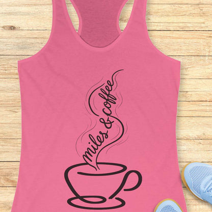 Pink tank top with a coffee cup design and 'miles & coffee' text on a wooden surface.