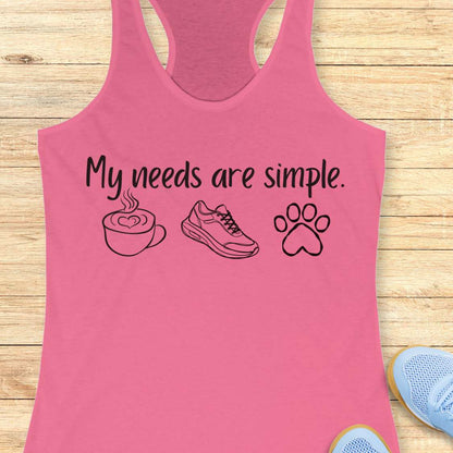 Pink tank top with text My needs are simple, and graphics on a wooden surface