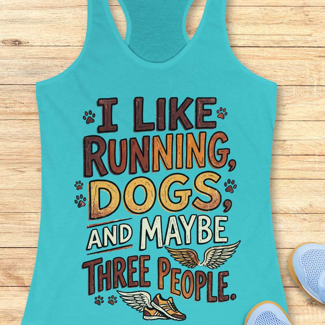 Turquoise tank top with text 'I like running, dogs, and maybe three people' on a wooden surface.