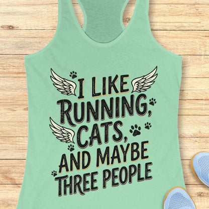 Mint green tank top with text 'I like running, cats, and maybe three people' on a wooden surface.