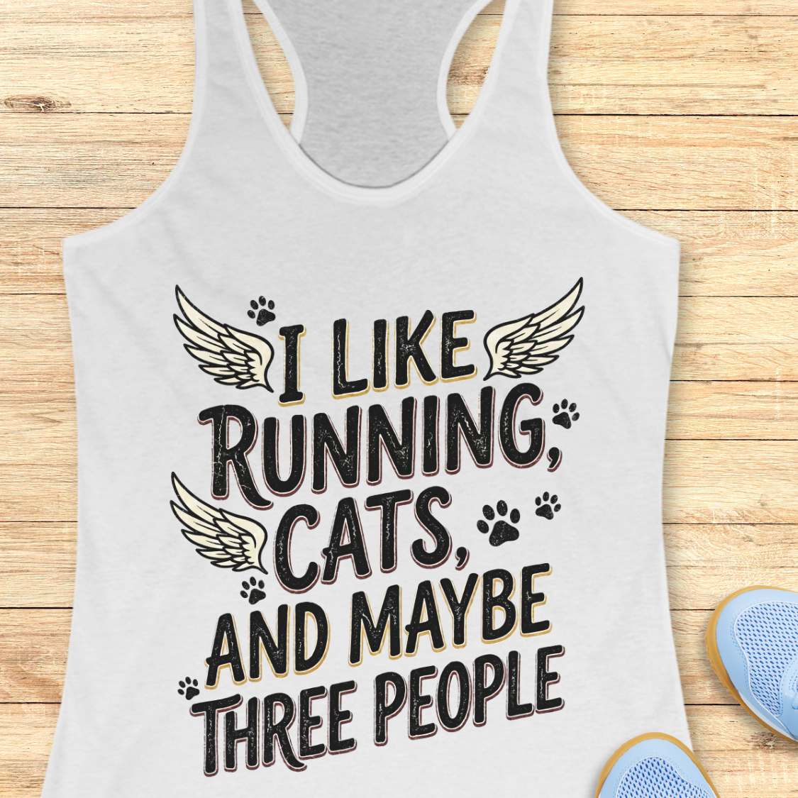 white tank top with text 'I like running, cats, and maybe three people' on a wooden surface.