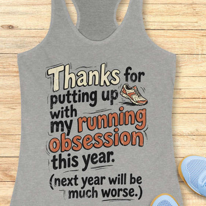 Gray tank top with humorous running text design on a wooden surface
