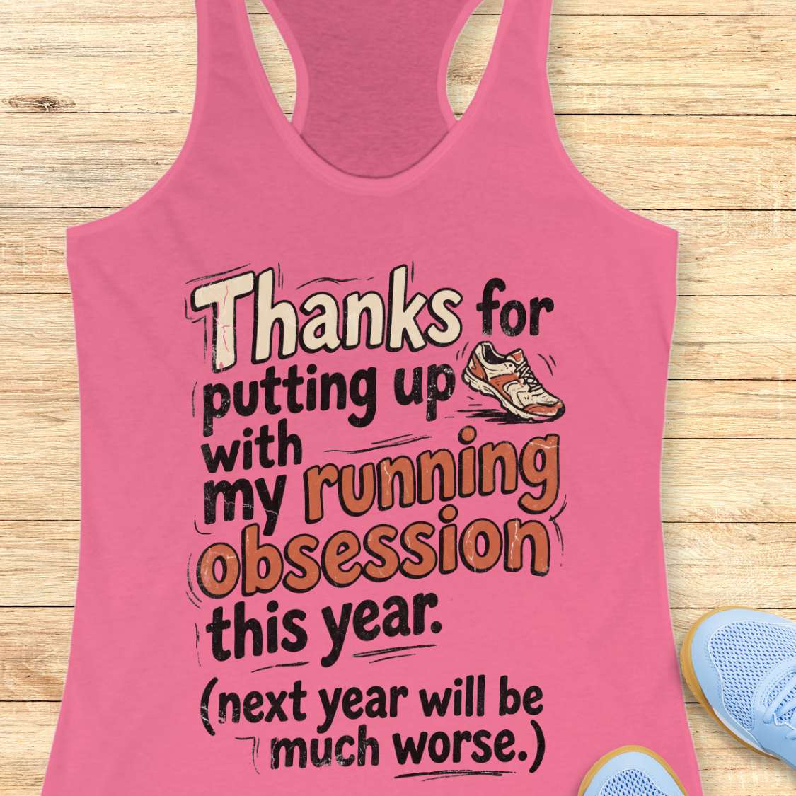 Pink tank top with humorous text on a wooden surface
